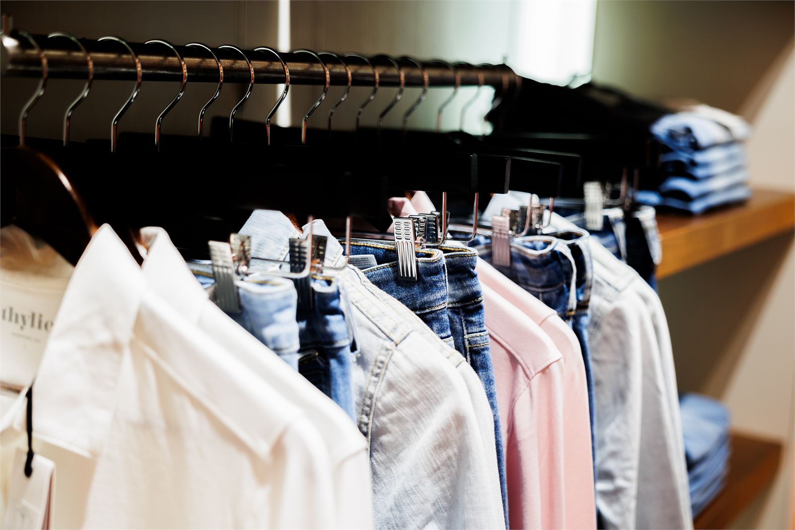 Kleiderstange mit Blusen und Kleidern in der Boutique Mode Lenk